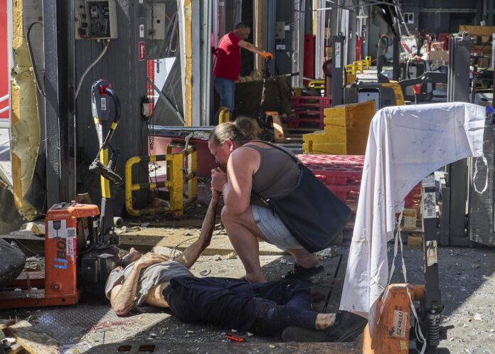 Járkov (Ucrania), 19/07/2026.- Una mujer llora junto al cuerpo de una de las persona muertas en un ataque ruso con misiles contra una terminal postal en un suburbio de la ciudad ucraniana de Járkov.
 EFE/EPA/SERGEY KOZLOV ATTENTION: GRAPHIC CONTENT
