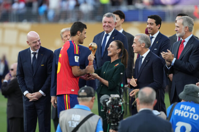 Rodri Hernández (ci) de España recibe el trofeo del Balón de Oro de manos de la presidenta de México, Claudia Sheinbaum (cd) este 19 de julio de 2026, en el estadio MetLife en Nueva Jersey. EFE/ Octavio Guzman
