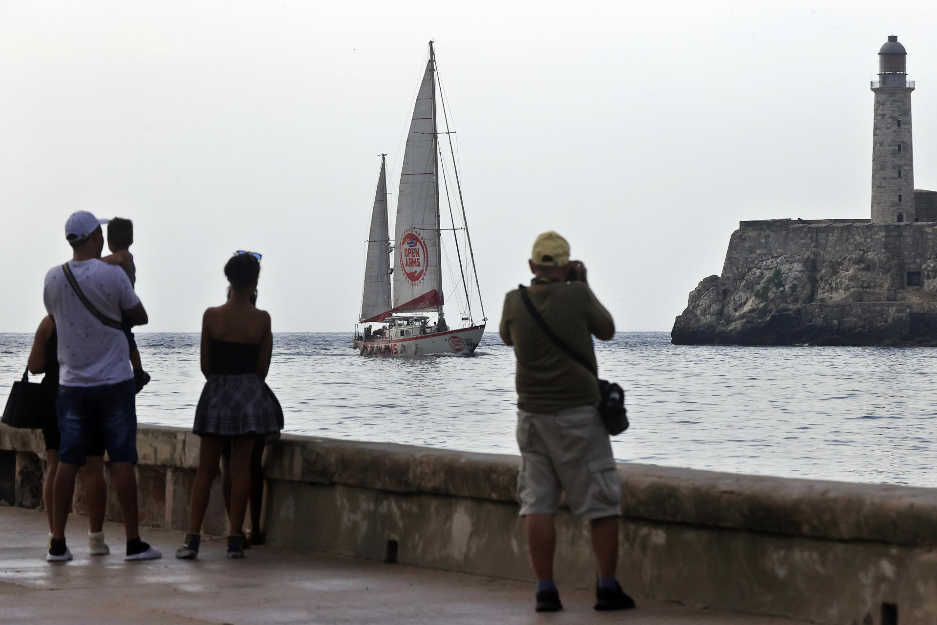 Personas observan la llegada del buque Astral, de la organización humanitaria Open Arms, al puerto de La Habana, como parte de la iniciativa 'Rumbo a Cuba', con equipos fotovoltaicos e insumos médicos destinados a un hospital pediátrico, para apoyar a la isla frente al bloqueo petrolero de Estados Unidos, este domingo, en La Habana (Cuba). EFE/ Ernesto Mastrascusa