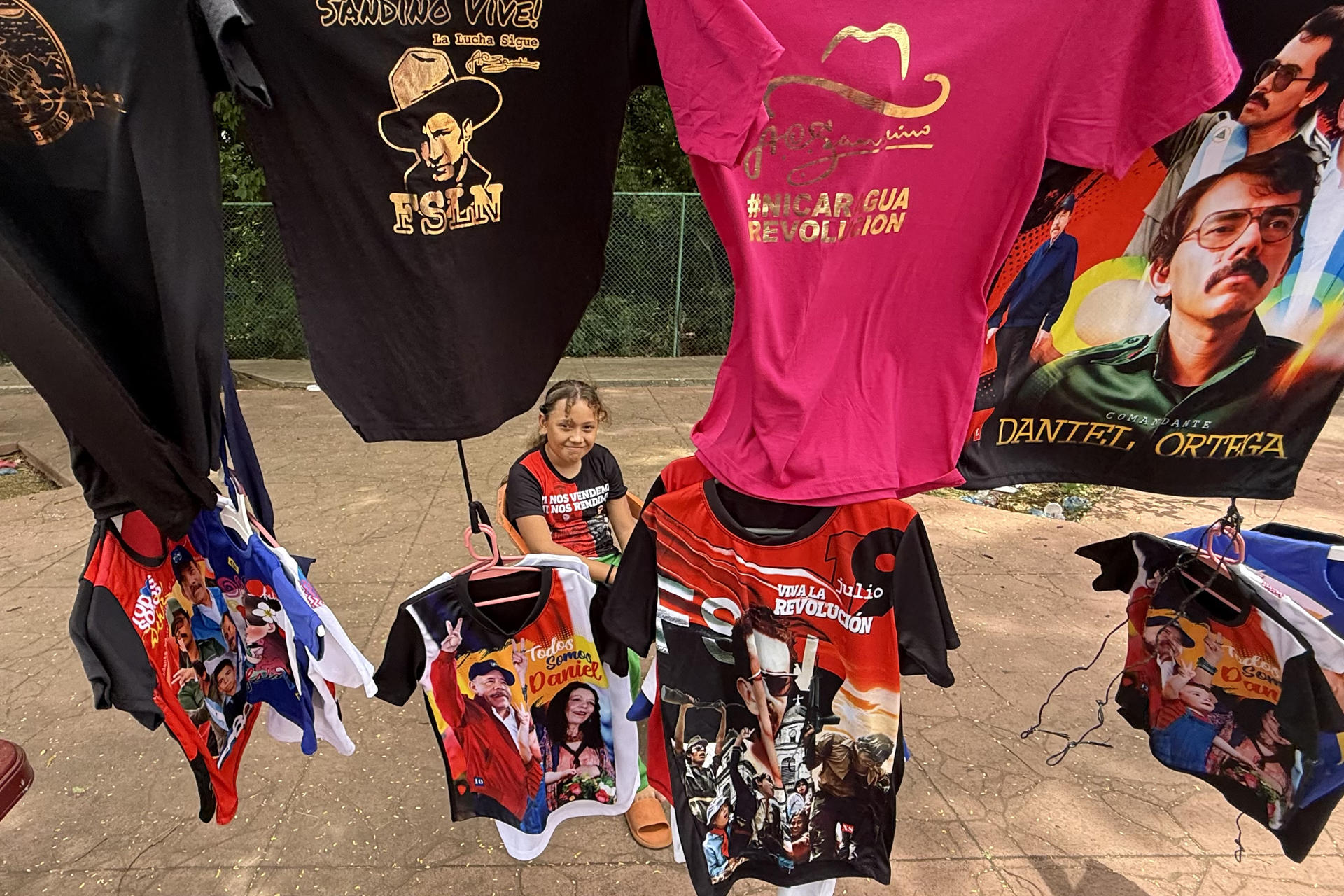 Una niña ayuda a vender a sus padres camisetas con imágenes estampadas del presidente de Nicaragua, Daniel Ortega, durante la celebración del 47 aniversario de la revolución que derrocó por la vía armada a la dictadura de Anastasio Somoza Debayle, este 19 de julio de 2026, en Managua (Nicaragua). EFE/ STR