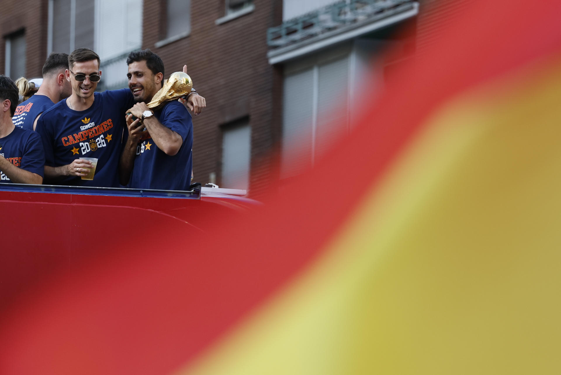 Los jugadores de la selección española Rodri (d) y Fabián Ruiz (i) a su paso por la calle Princesa de Madrid durante la celebración tras proclamarse ayer campeones del mundo al derrotar en la final a Argentina. EFE/ Ballesteros