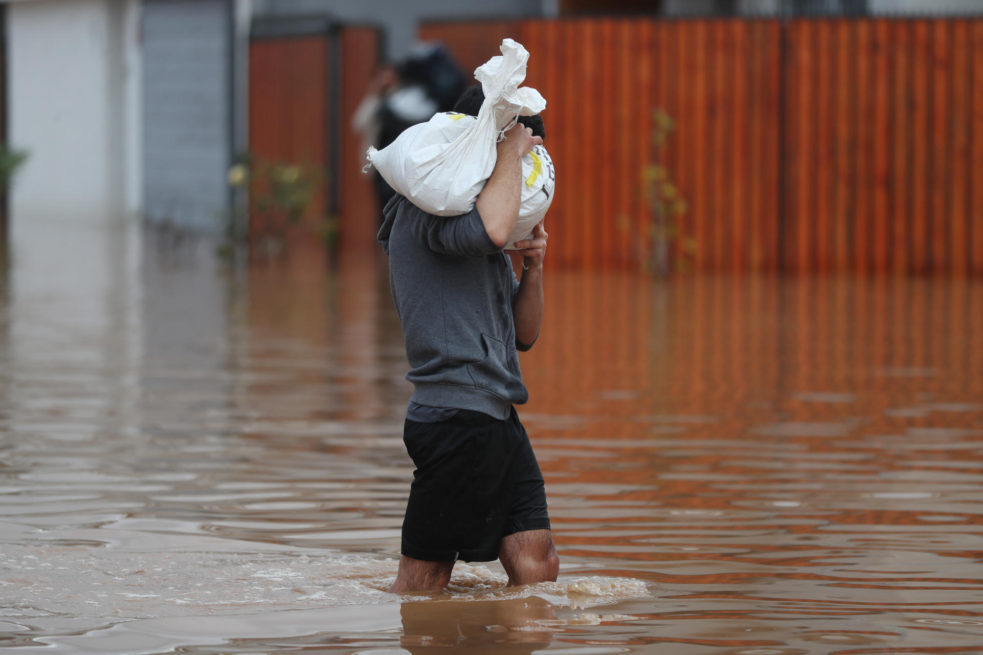 Una persona camina por una calle inundada por el desborde del Canal Bellavista, este lunes en el barrio Mirador de Hacienda, en La Serena (Chile). EFE/ Hernán Contreras