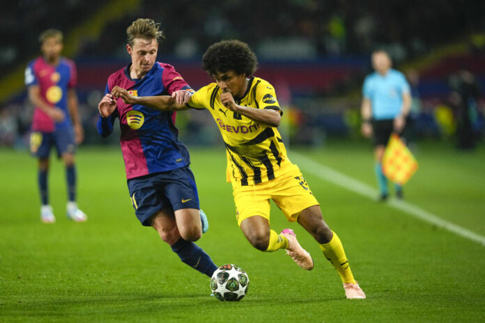 Imagen de archivo en la que el delantero Karim Adeyemi (d), intenta llevarse el balón con su anterior equipo, el Borussia Dortmund, ante el centrocampista neerlandés del FC Barcelona, Frenkie de Jong, durante el encuentro correspondiente a la ida de los cuartos de final de la Liga de Campeones que disputaron FC Barcelona y el equipo alemán en el Estadio Olímpico de Montjuic, en Barcelona. EFE / Alejandro García.
