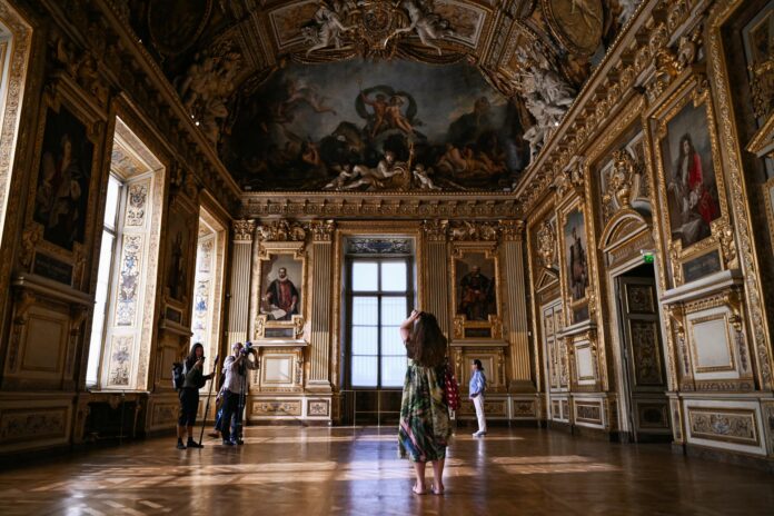 Un grupo de personas recorre la Galería Apolo del Museo del Louvre, en París, que acaba de reabrir sus puertas al público. EFE/EPA/LOU BENOIST / POOL MAXPPP OUT
