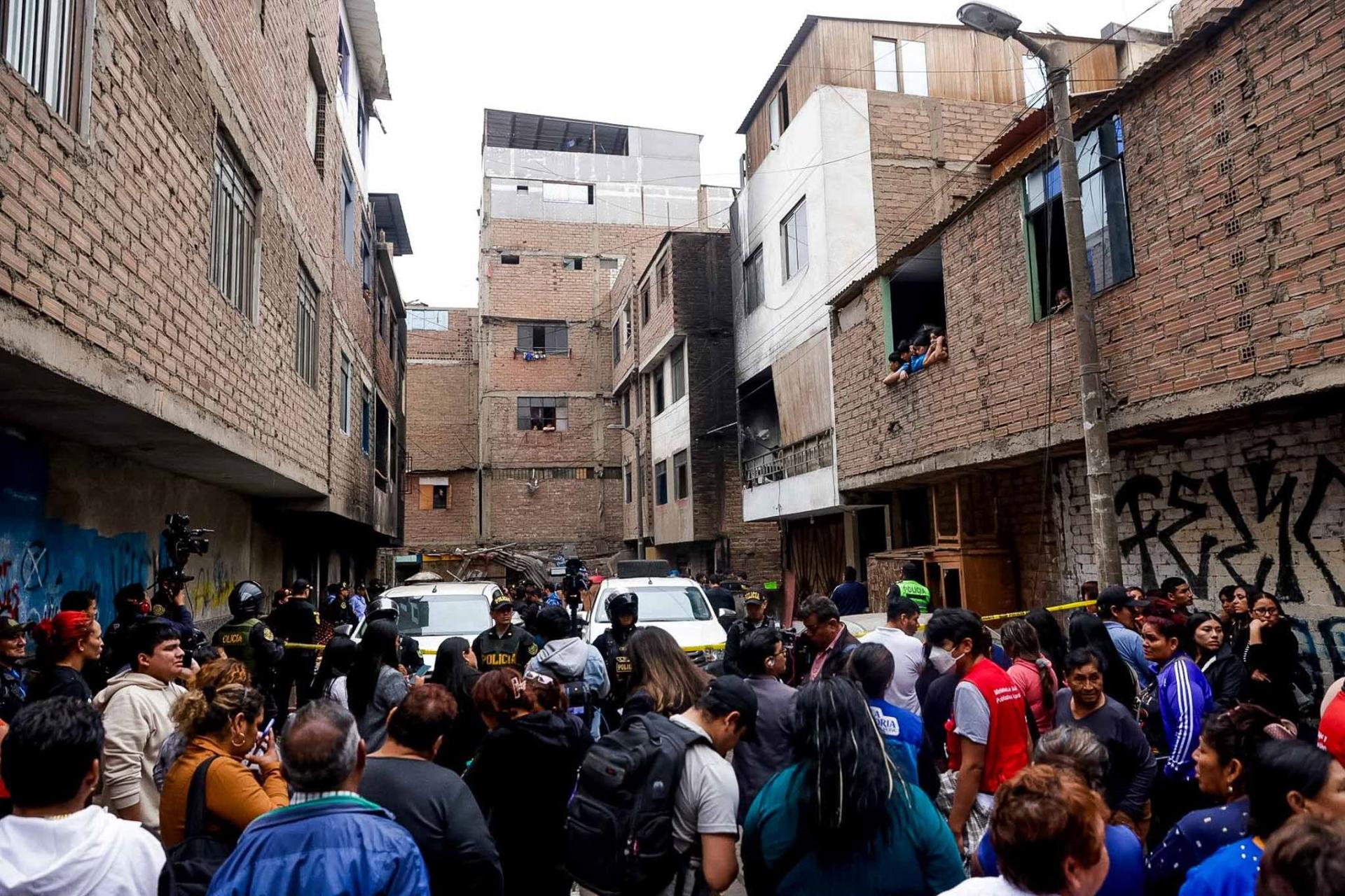 Fotografía cedida por la Agencia Andina que muestra a integrantes de la Policía de Perú custodiando varias viviendas tras un incendio en Lima (Perú). EFE/ Luis Iparraguirre