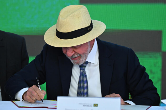 El presidente de Brasil, Luiz Inácio Lula da Silva, firma un documento durante la ceremonia de sanción del Proyecto de Ley de Conversión, que asigna recursos a las líneas de crédito del programa 'Brasil Soberano' en apoyo de las empresas afectadas por los aranceles comerciales de Estados Unidos, este miércoles en el Palacio de Planalto, en Brasilia (Brasil). EFE/ Andre Borges
