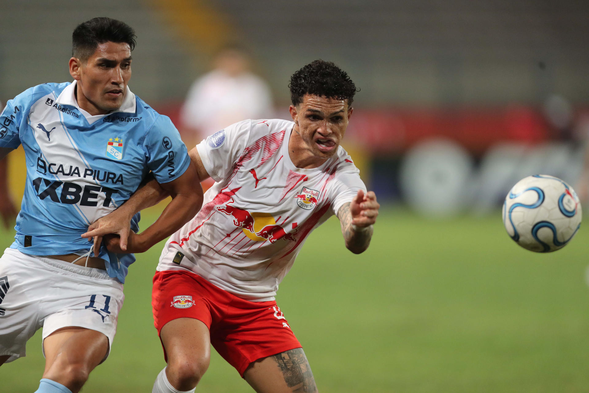 Irven Avila (i), de Sporting Cristal, disputa el balón con Gustavo Neves, de Bragantino este miércoles en el partido de ida por un cupo en los octavos de final de la Copa Sudamericana jugado en el estadio Nacional en Lima (Perú). EFE/ Paolo Aguilar
