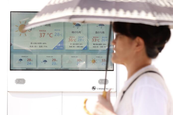 TOKIO (Japón), 22/07/2026.- Un peatón sostiene una sombrilla mientras pasa junto a una pantalla que muestra 37 grados Celsius, en Tokio, Japón, el 22 de julio de 2026.
EFE/EPA/RODRIGO REYES MARIN
