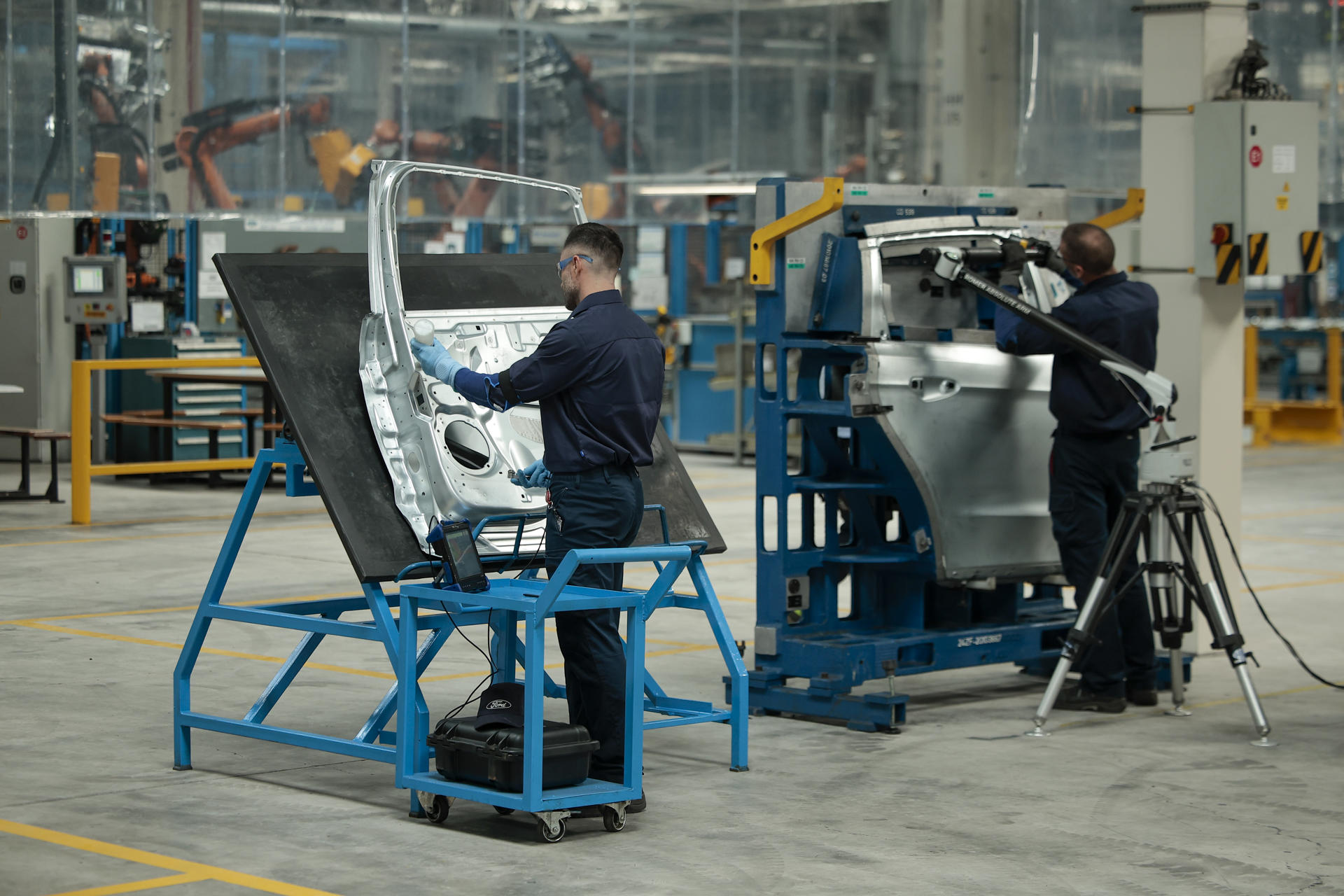 Dos operarios trabajan en la factoría de Ford en Almussafes (Valencia) este jueves en el que el presidente del Gobierno, Pedro Sánchez, visita la planta con motivo de un anuncio corporativo importante por parte de la compañía relativo a sus operaciones en Europa y a la planta valenciana. EFE/Biel Aliño
