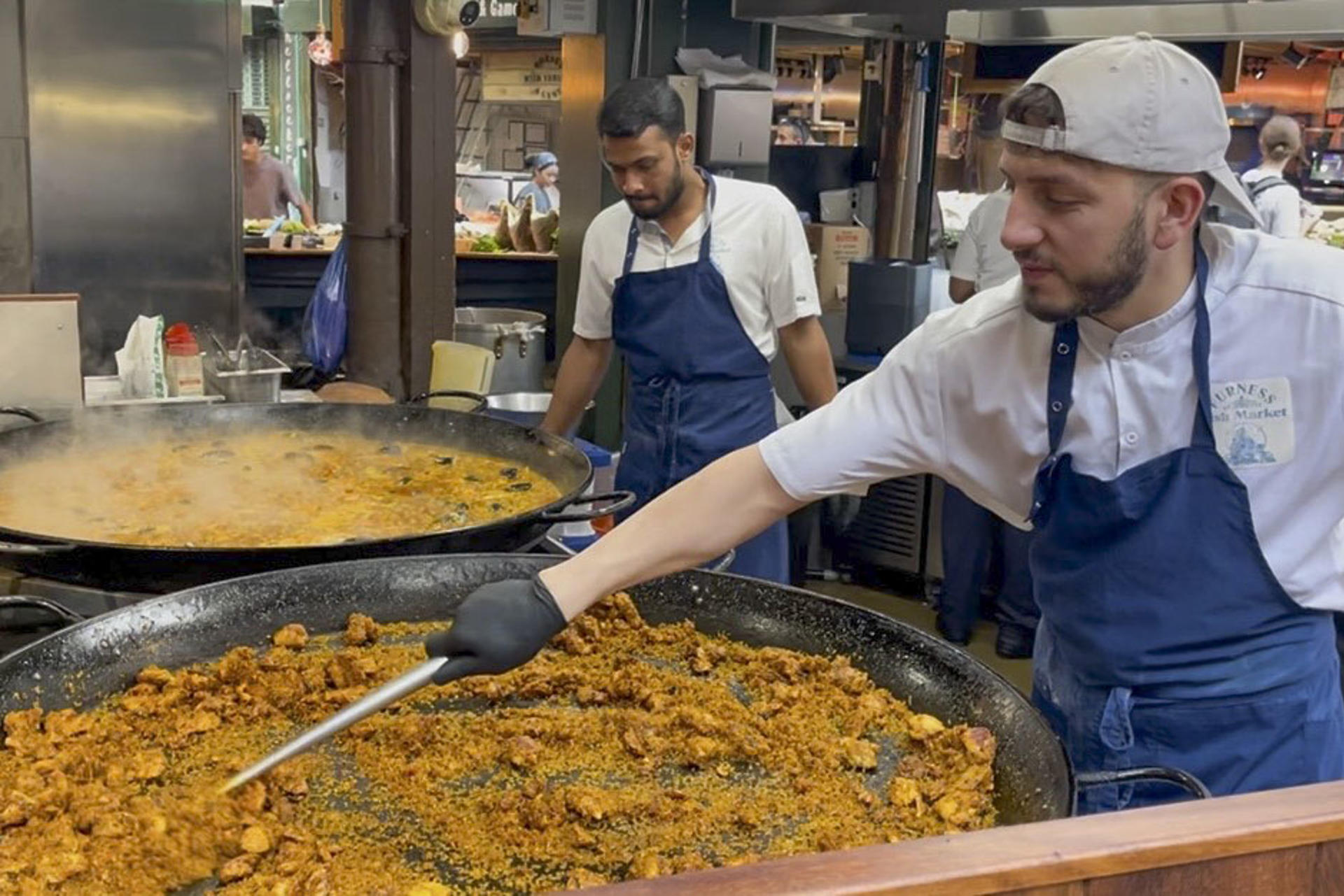 El mercado gastronómico de Borough, uno de los más populares de Londres, recibe a diario largas colas de visitantes para comprar una porción de paella en el puesto de arroces que causa furor entre los turistas y visitantes y donde se venden más de 1.000 raciones a diario. Son las diez de la mañana y huele a aceite de oliva, ajo, cebolla, pimiento y tomate rallado, el tradicional sofrito de paella. También se escucha cómo las cucharas rascan el fondo de la paellera para obtener el característico 'socarrat'. Esta escena podría ser la típica imagen, salvando la hora, en cualquier restaurante, bar o calle del Mediterráneo español. Sin embargo, el lugar es el mercado gastronómico de Borough en Londres.-EFE/ Luis Campello