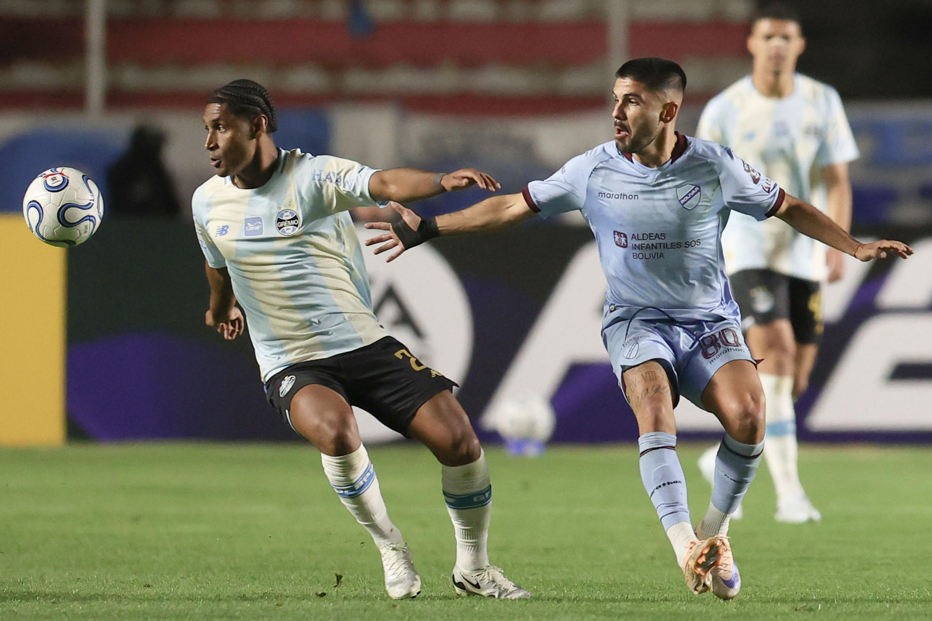 Carlos Melgar (d), de Bolívar, disputa el balón con Tetê, de Gremio, en un partido de la Copa Sudamericana entre Bolívar y Gremio en el estadio Hernando Siles en La Paz (Bolivia). EFE/ Luis Gandarillas
