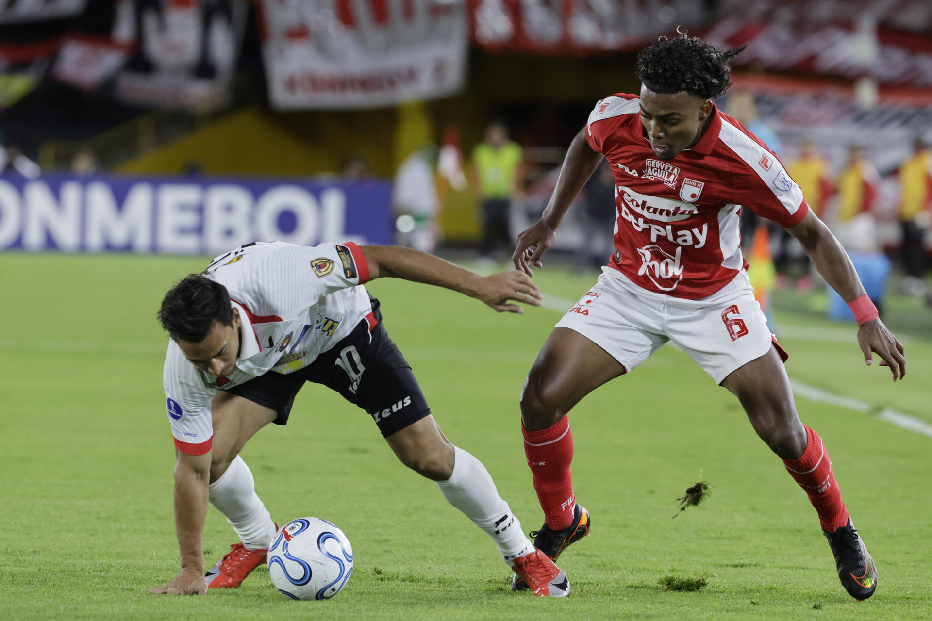 Kilian Toscano (d), de Santa Fe, disputa un balón con Michael Covea, de Caracas, en un partido de la Copa Sudamericana entre Santa Fe y Caracas en el estadio El Campín en Bogotá (Colombia). EFE/ Carlos Ortega