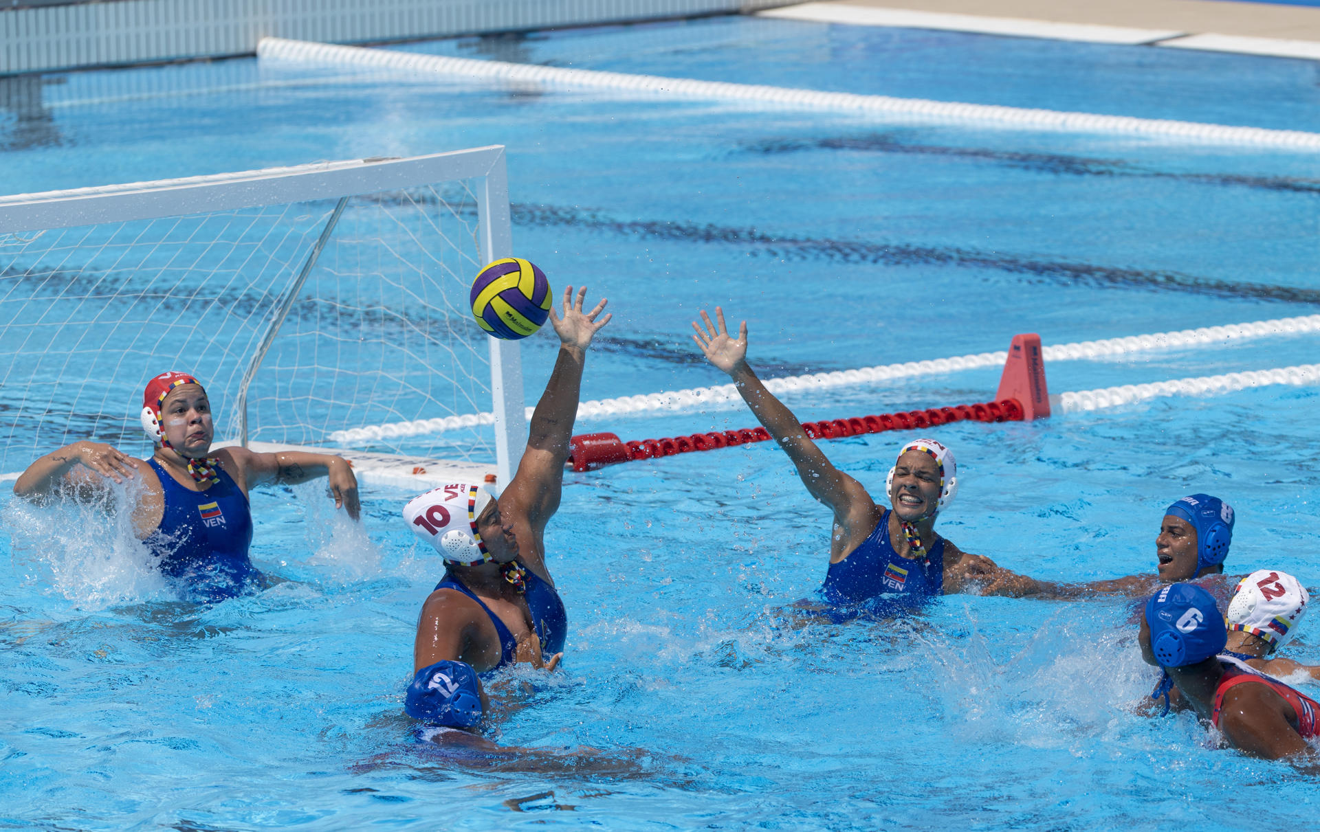 La venezolana Beatriz Escobar (c-i) disputa el balón con la cubana Alejandra Aranguren (c-abajo) en un partido rumbo a la final de Polo Acuático de los XXV Juegos Centroamericanos y del Caribe. EFE/Orlando Barría