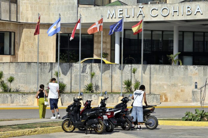 Personas caminan frente a un hotel de la cadena hotelera española Meliá este pasado martes, en La Habana (Cuba). EFE/ Ernesto Mastrascusa
