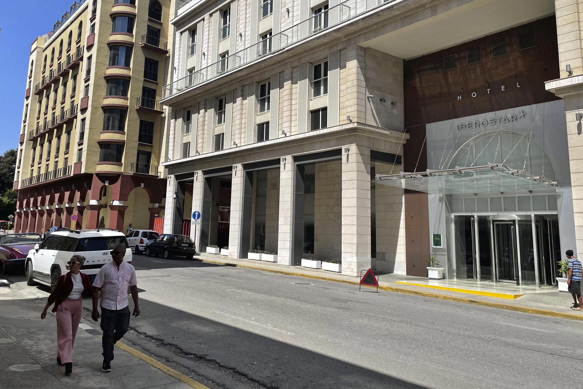 Personas caminan frente a un hotel de la cadena hotelera española Iberostar este pasado miércoles, en La Habana (Cuba). EFE/ Ernesto Mastrascusa

