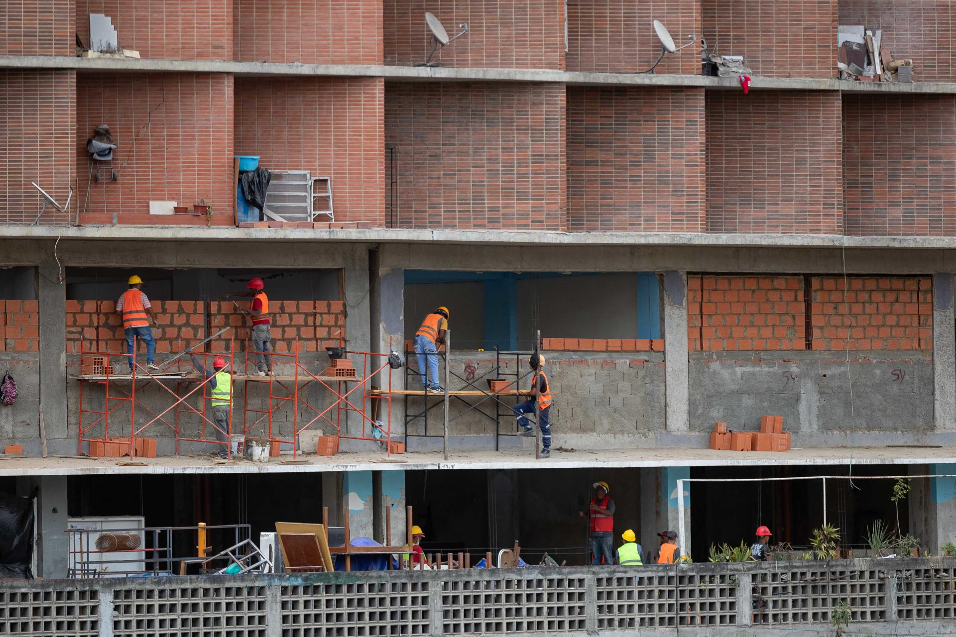 Personas trabajan en la reconstrucción de un edificio afectado por los terremotos del pasado 24 de junio, en Caracas (Venezuela). EFE/ Ronald Peña R