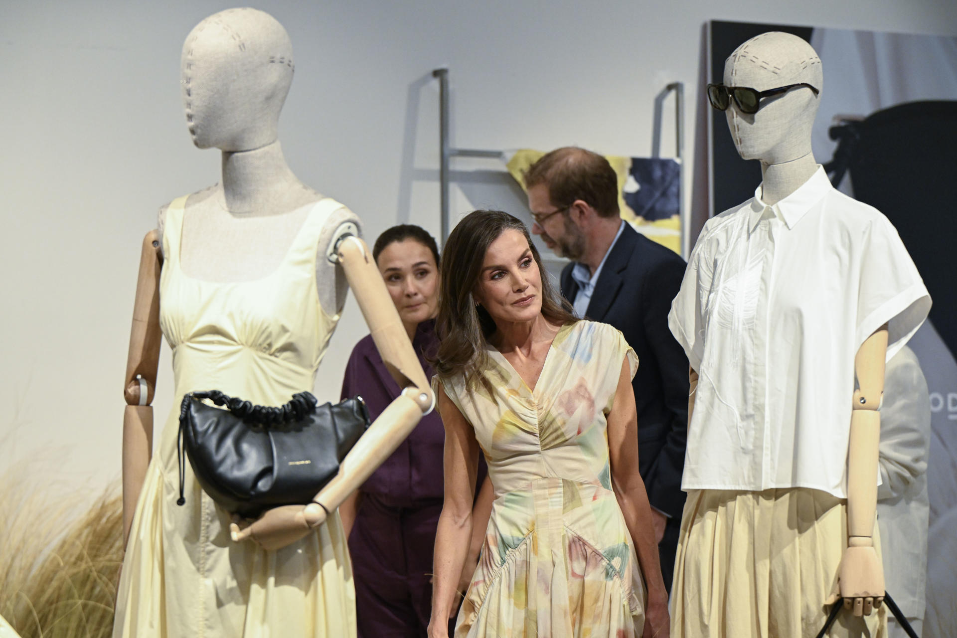 La reina Letizia (c) junto a la presidenta ejecutiva de Adolfo Domínguez, Adriana Domínguez (i) visita este viernes, 24 de julio, víspera del Día de Galicia, las instalaciones de Adolfo Domínguez en San Cibrao (Ourense) por los 50 años de la firma decana de la moda española y la primera en cotizar en bolsa, cuyas riendas llevan ahora las hijas del diseñador gallego. EFE/ Brais Lorenzo