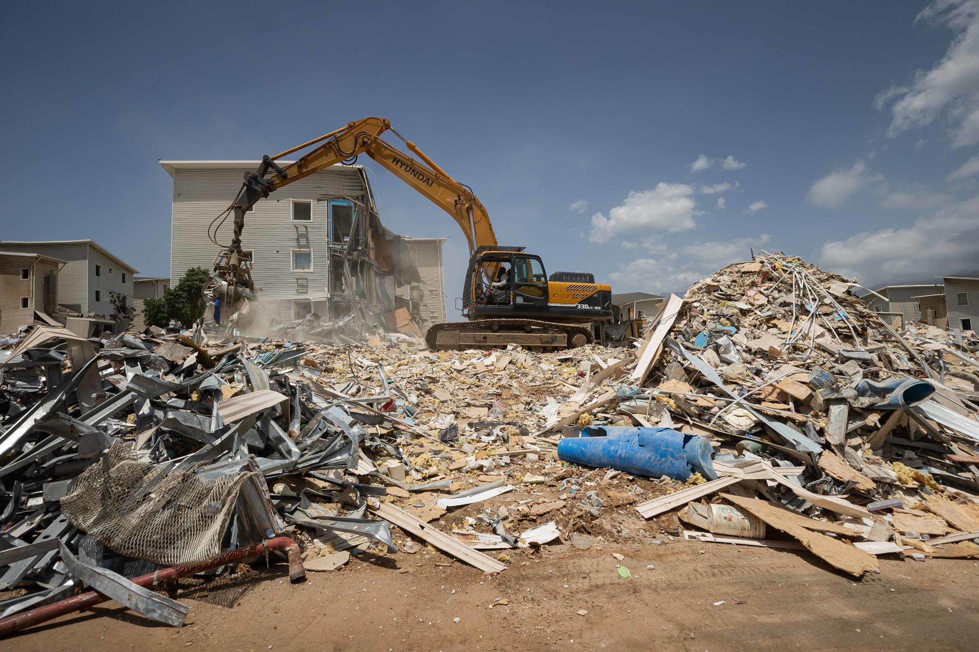 Vista general de una retroexcavadora al remover escombros en una zona afectada por los terremotos del pasado 24 de junio, en Catia La Mar (La Guaira, Venezuela). EFE/Ronald Peña