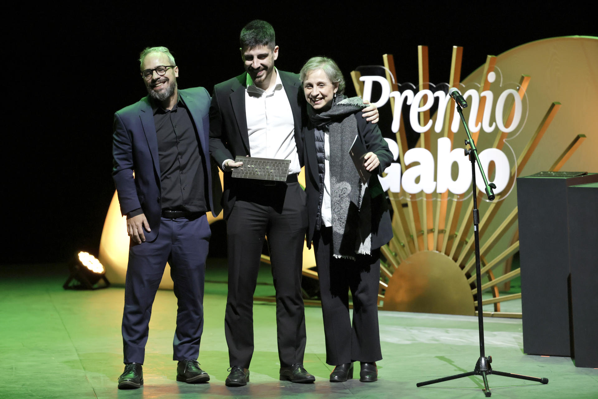 Los periodistas Artur Rodrigues (i) y Renan Porto (c) reciben el premio como ganadores en la categoría Cobertura durante la ceremonia de entrega del los Premios Gabo en el Teatro Municipal Jorge Eliécer Gaitán este viernes, en Bogotá (Colombia). EFE/ Carlos Ortega
