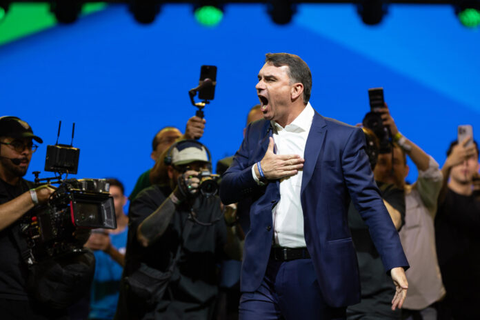 El senador de Brasil Flávio Bolsonaro (d) reacciona en la convención nacional del Partido Liberal de Brasil (PL) este sábado, en São Paulo (Brasil). El PL que lidera el expresidente Jair Bolsonaro, dio inicio a la convención para proclamar a su hijo mayor, Flávio, como candidato presidencial para las elecciones del próximo octubre. EFE/ Isaac Fontana
