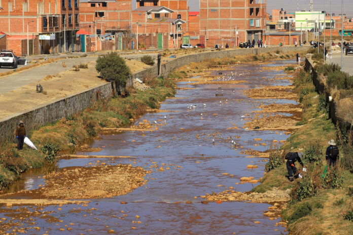 Personas participan en una jornada de limpieza del río Seke, contaminado por basura y otros desechos que desembocan en el lago Titicaca, este sábado en El Alto (Bolivia). EFE/ Gabriel Márquez
