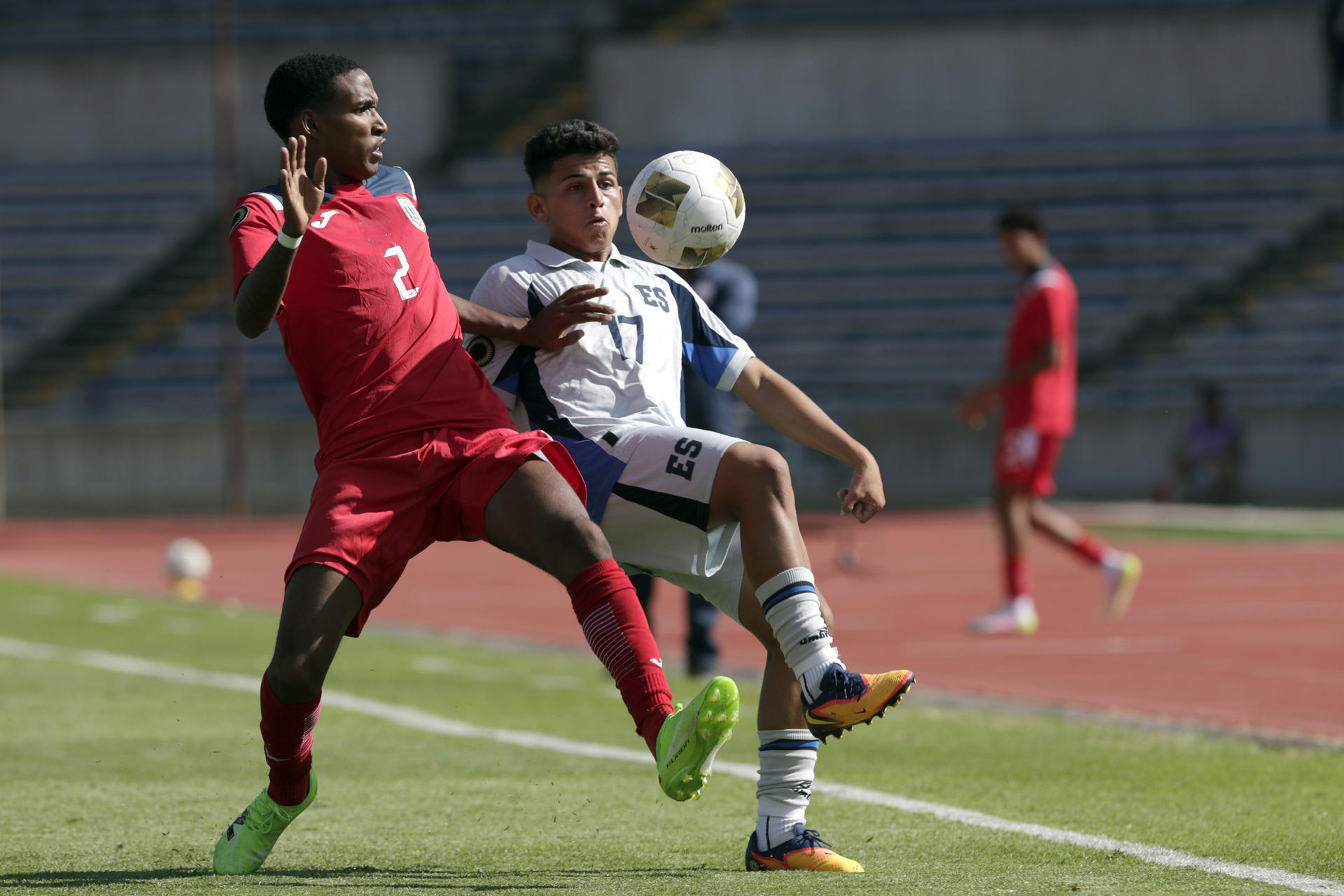 El cubano Yeasy Quiñones (i) disputa el balón con el salvadoreño Uriel Miranda este sábado durante el partido del torneo clasificatorio sub-20 de la Concacaf para los Juegos Olímpicos de Los Ángeles 2028 que se disputa en la ciudad cubana de Puebla. EFE/ Hilda Ríos
