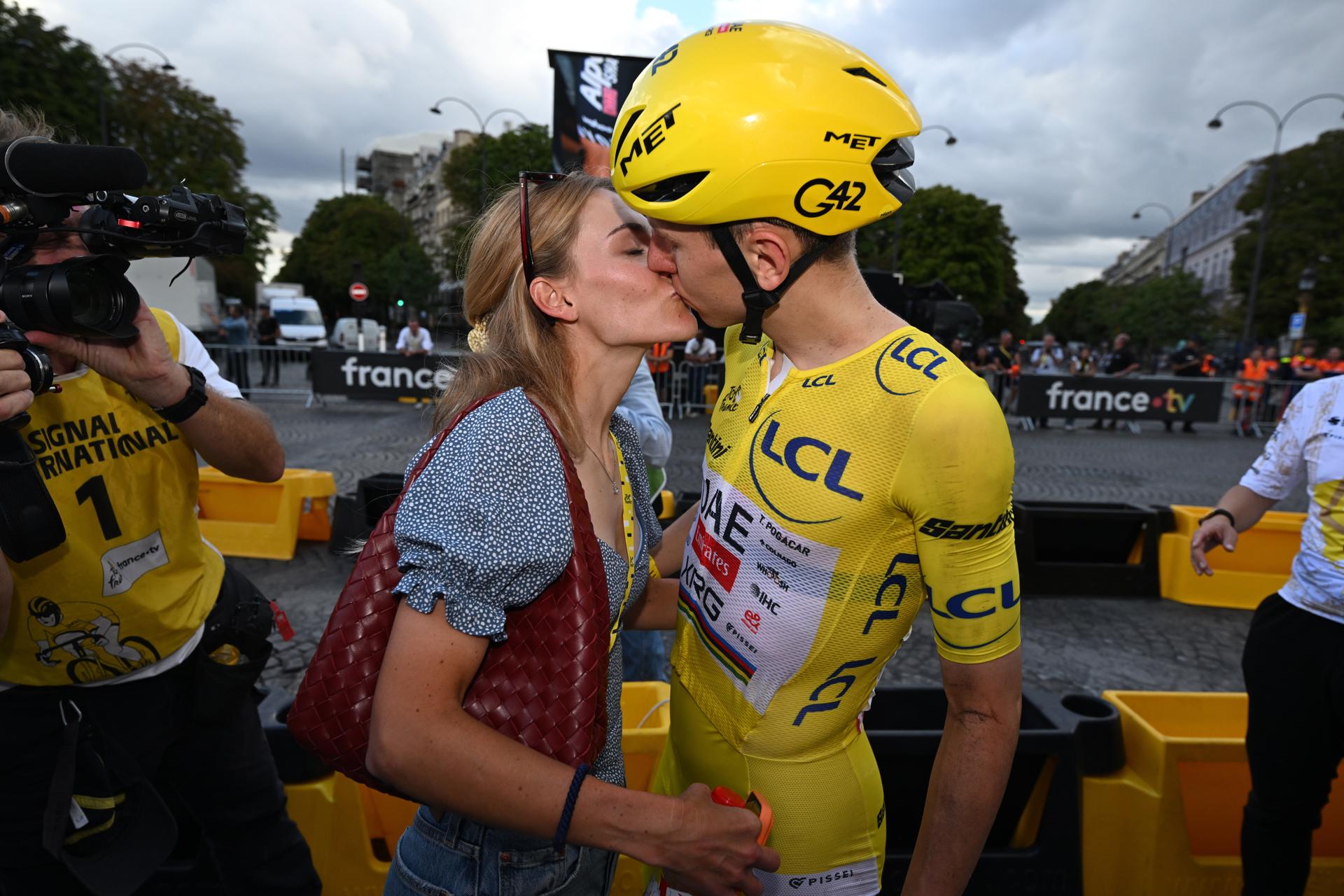 El campeón por quinta vez del Tour de Francia, el esloveno Tadej Pogacar del UAE Team Emirates XRG celebra con su novia, la también ciclista Urska Zigart, el triunfo logrado al término de la última etapa. (Ciclismo, Francia) EFE/EPA/DARIO BELINGHERI / POOL
