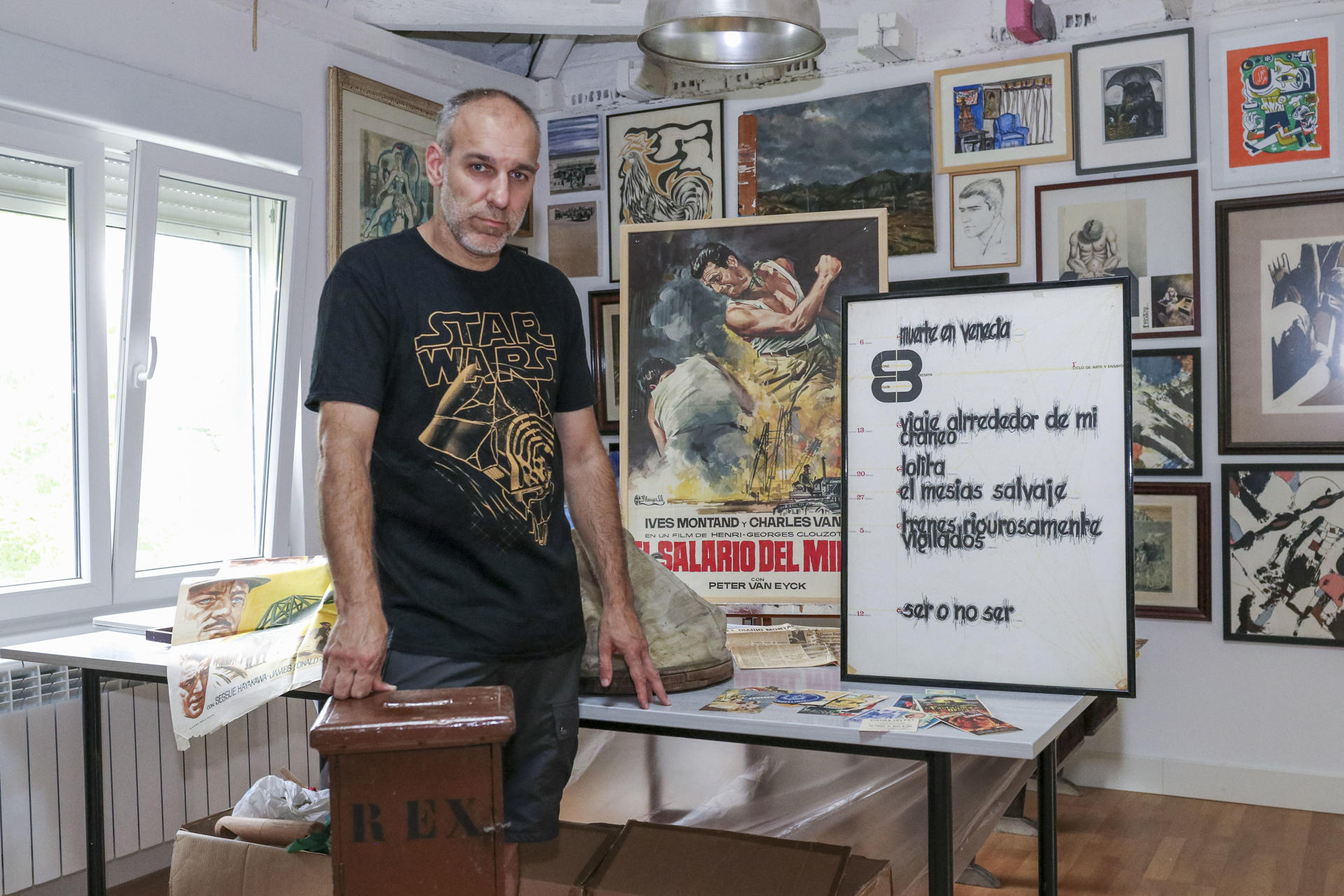 El artista plástico Aris Rosino muestra alguno de los materiales que está recogiendo de cara a organziar una exposición que reconstruirá la historia de cines de Torrelavega, con fotografías, carteles originales, entradas, programas de mano, testimonios y objetos conservados durante décadas en cajones y colecciones particulares.EFE/Javier G. Paradelo
