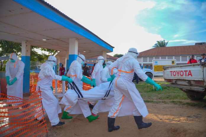 Personal médico con equipos de protección transporta el cuerpo de una víctima de ébola en la República Democrática del Congo (RDC). EFE/EPA/DIEUDONNE DIROLE
