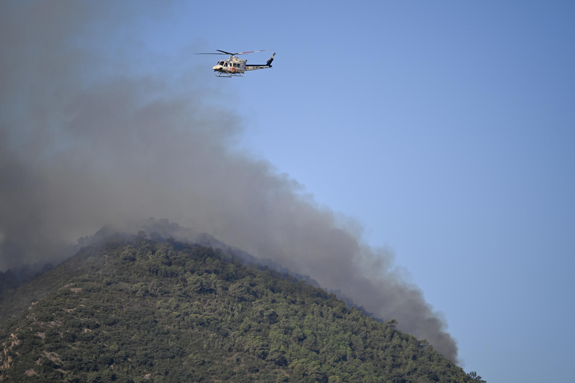 Un helicóptero trabaja en la extinción del incendio forestal de la provincia española de Castellón (este) . EFE/ Andreu Esteban
