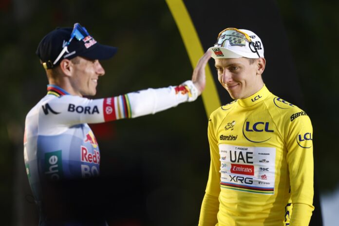 El belga Remco Evenepoel (i), segundo en el podio del Tour de Francia, y el ganador de la prueba, el esloveno Tadej Pogacar (d), este domingo en París. EFE/YOAN VALAT
