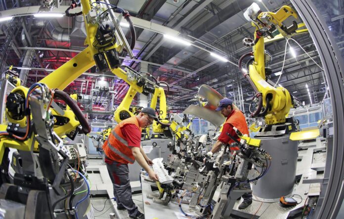 Imagen de archivo de trabajadores instalando un robot en la fábrica de Porsche en Leipzig, Alemania . EFE/Jan Woitas
