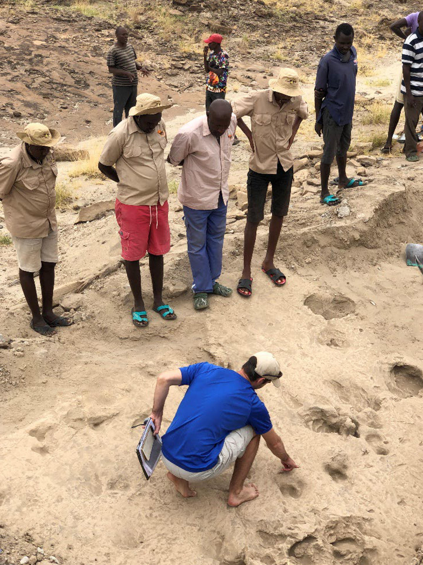 El investigador Kevin Hatala y sus colegas analizan las huellas prehistóricas descubiertas en el norte de Kenia en 2023. Crédito: Kay Behrensmeyer, paleobióloga del Museo de Historia Natural Smithsonian de Estados Unidos
