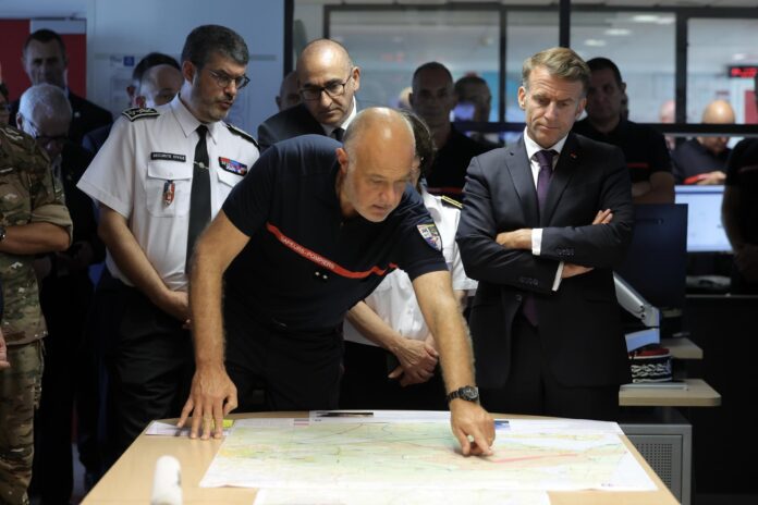 El presidente de Francia, Emmanuel Macron (derecha), y el ministro del Interior francés, Laurent Núñez (centro, atrás), asisten a una sesión informativa sobre la situación en la sala de crisis del Centro Operativo Departamental de Bomberos y Rescate (CODIS) en Burdeos, tras los incendios forestales registrados en esa zona del suroeste de Francia. EFE/EPA/KENZO TRIBOUILLARD / POOL
