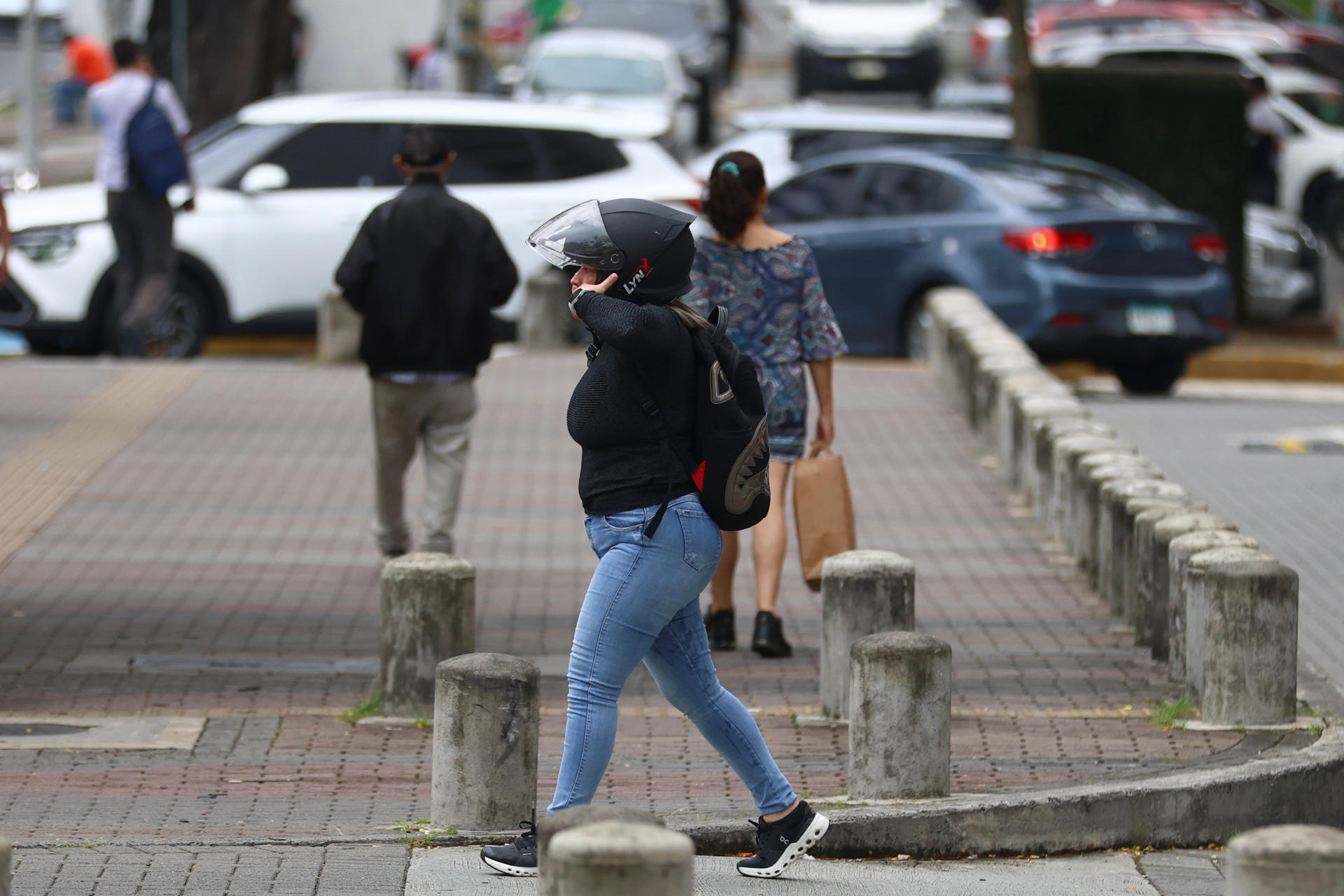 Una mujer con un casco fue captada este 27 de julio al caminar por una calle de Ciudad de Panamá (Panamá). EFE/Carlos Lemos
