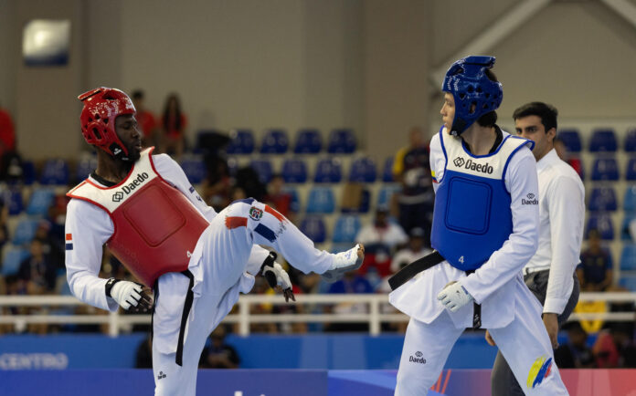 Bernardo Pie (i), de República Dominicana, enfrenta a Damián Gil, de Colombia, este lunes en un combate de taekwondo kyorugui -74 kg, durante los XXV Juegos Centroamericanos y del Caribe Santo Domingo 2026. EFE/ Orlando Barría
