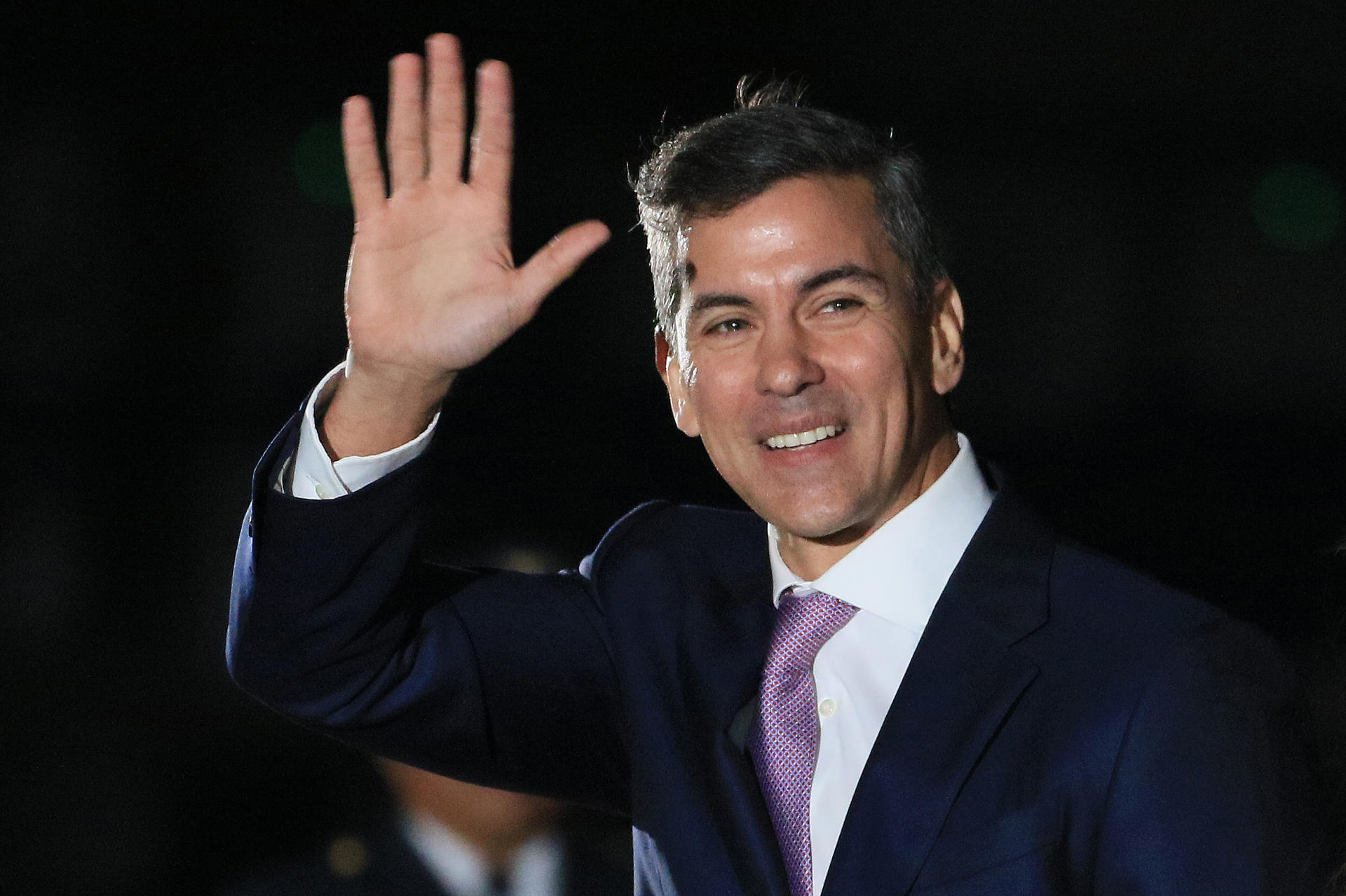 El presidente de Paraguay, Santiago Peña, saluda a su llegada este lunes, para asistir a los actos oficiales de la transmisión de mando e investidura programados para el martes, de la presidenta electa de Perú, Keiko Fujimori, en Lima (Perú). EFE/ Germán Falcón
