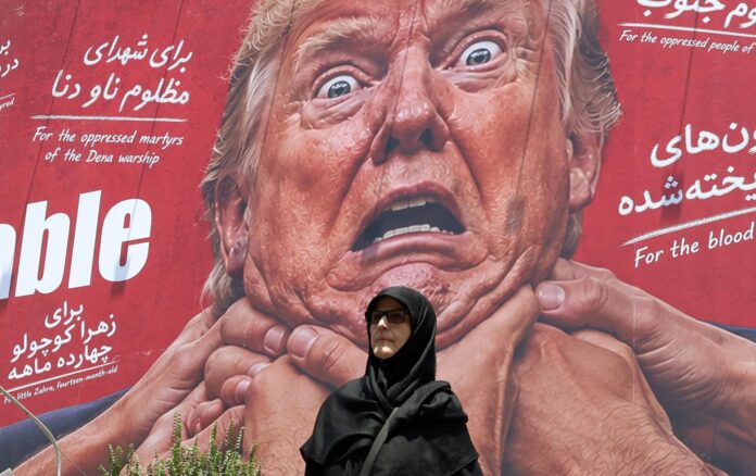Una mujer pasa junto a una valla publicitaria antiestadounidense y anti-Trump en una calle de Teherán, Irán, este lunes. Estados Unidos e Irán suspendieron los ataques y represalias para impulsar esfuerzos diplomáticos que pongan fin al conflicto por el estrecho de Ormuz. EFE/EPA/ABEDIN TAHERKENAREH. RESTRICCIONES: Prohibido el acceso a medios de comunicación israelíes/canales de televisión en persa fuera de Irán/Prohibido el acceso a BBC Persian/VOA Persian/Manoto TV/Televisión Internacional de Irán. (Según lo dispuesto por la Dirección General de Medios de Comunicación Extranjeros de Irán).
